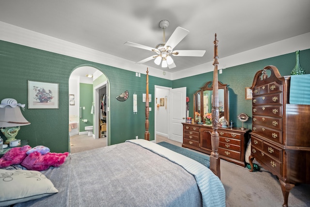 carpeted bedroom featuring ceiling fan and ensuite bath