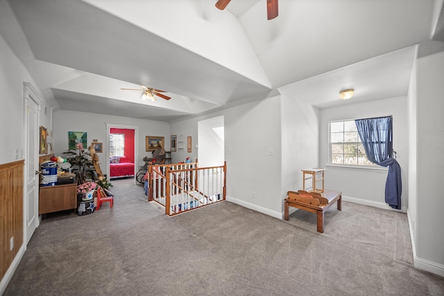 living area featuring lofted ceiling, plenty of natural light, ceiling fan, and carpet