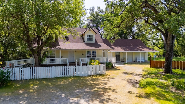 6024 Hornbeck Ln, Anderson, CA 96007 - new england style home featuring a fenced front yard, driveway, and covered porch