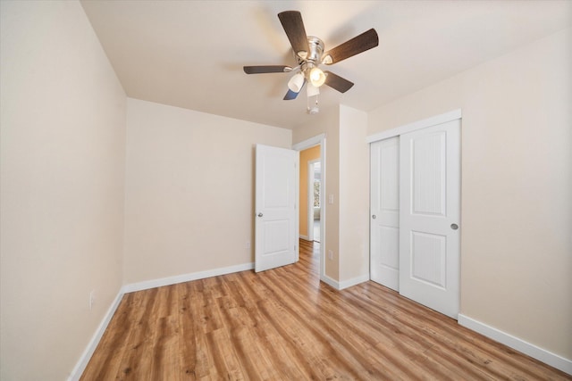 unfurnished bedroom with light hardwood / wood-style floors, ceiling fan, and a closet