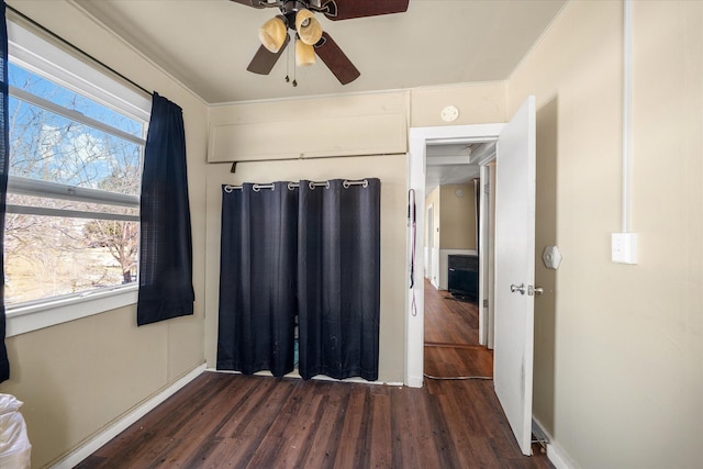 bedroom featuring multiple windows, dark hardwood / wood-style floors, and ceiling fan