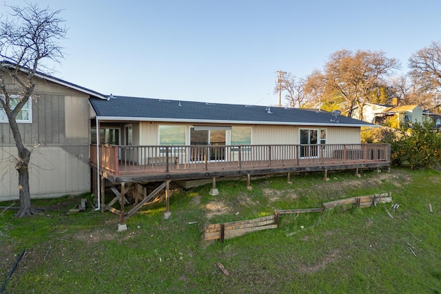 back of house with a wooden deck and a yard