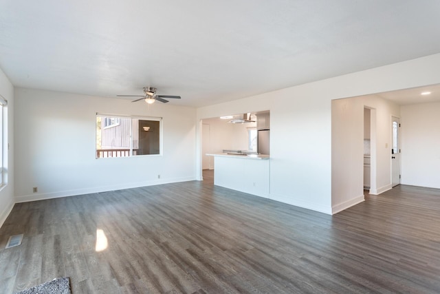 unfurnished living room featuring plenty of natural light, dark hardwood / wood-style floors, and ceiling fan