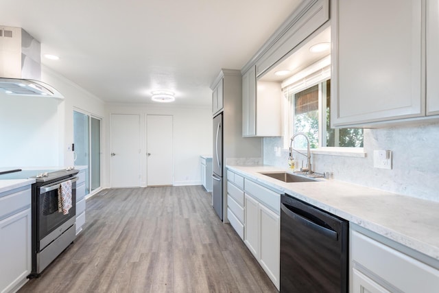 kitchen with sink, white cabinets, stainless steel appliances, and wall chimney exhaust hood