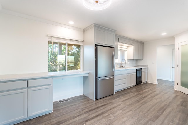 kitchen with sink, plenty of natural light, tasteful backsplash, and stainless steel refrigerator