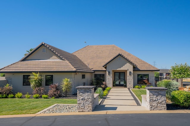 view of front facade with a front lawn and french doors