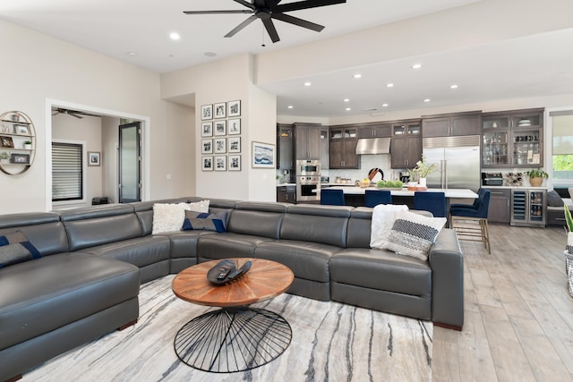 living room with ceiling fan, wine cooler, and light hardwood / wood-style floors