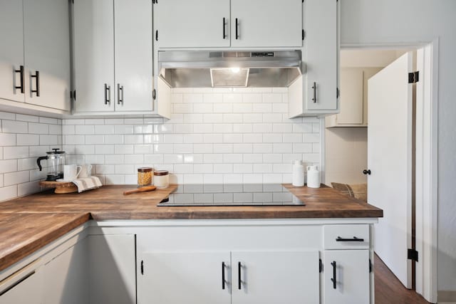 kitchen with white cabinetry, black electric cooktop, exhaust hood, and wood counters