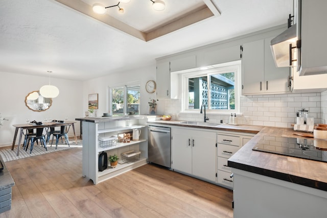 kitchen with sink, white cabinetry, decorative light fixtures, dishwasher, and a raised ceiling