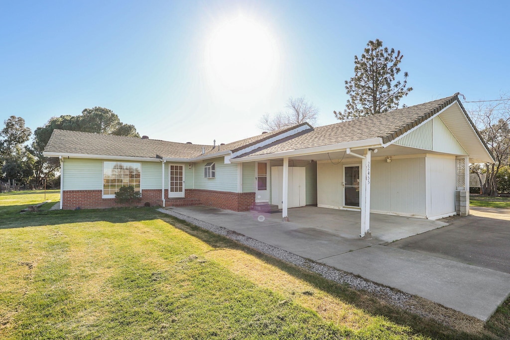 ranch-style home featuring a carport and a front yard