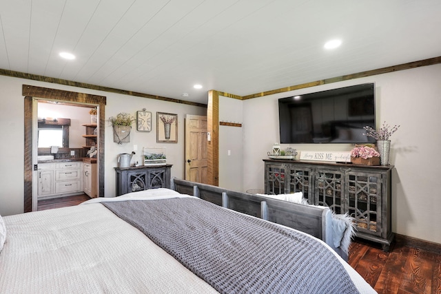 bedroom featuring dark wood-type flooring and ensuite bath