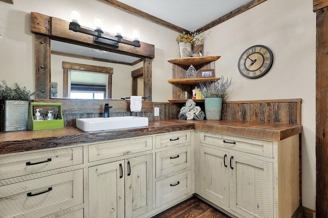 bathroom featuring tasteful backsplash, ornamental molding, hardwood / wood-style floors, and vanity