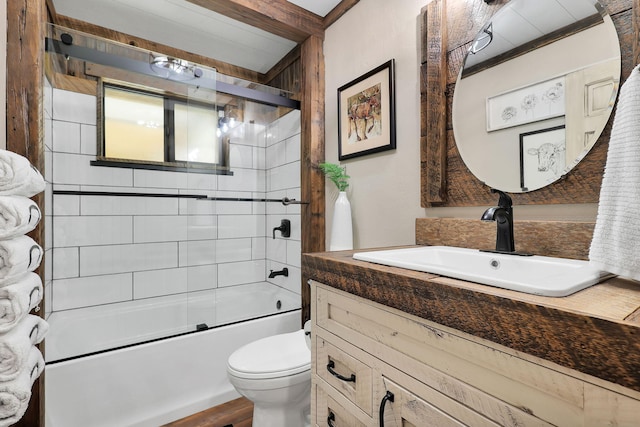 full bathroom featuring vanity, combined bath / shower with glass door, and toilet