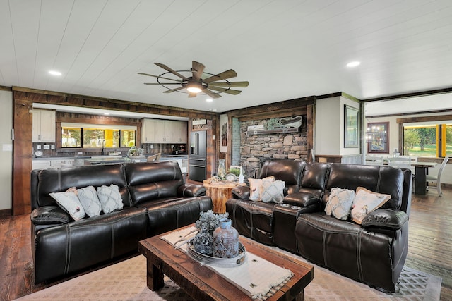 living room with sink, light wood-type flooring, a healthy amount of sunlight, and ceiling fan