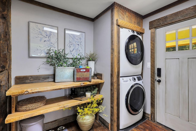 washroom with stacked washing maching and dryer and dark hardwood / wood-style flooring