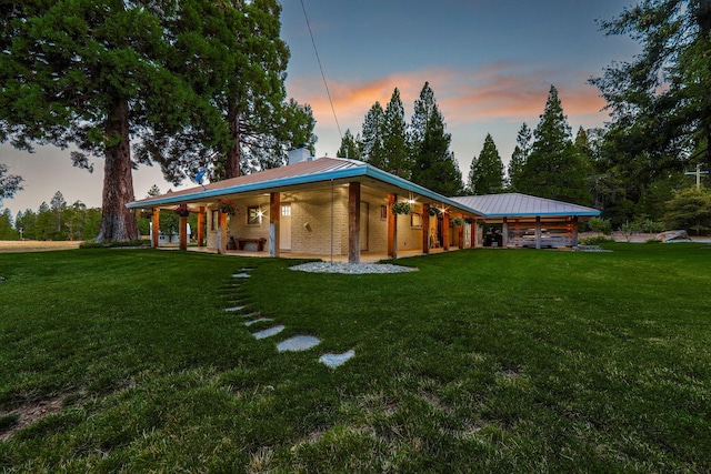 back house at dusk with a lawn