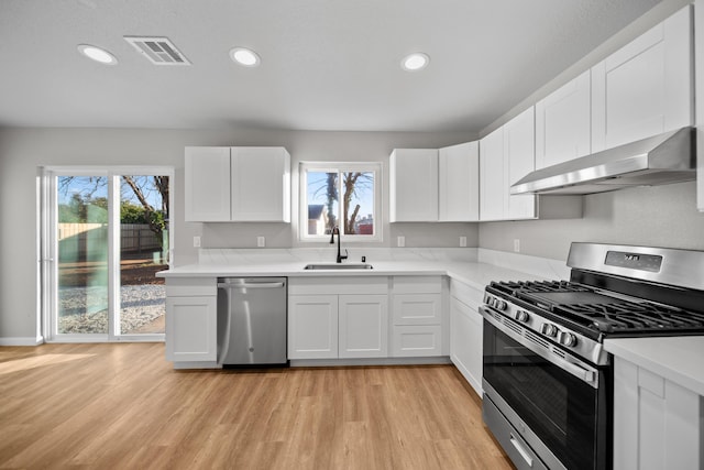 kitchen featuring white cabinetry, appliances with stainless steel finishes, sink, and extractor fan