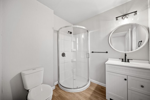 bathroom featuring a shower with door, vanity, hardwood / wood-style floors, and toilet