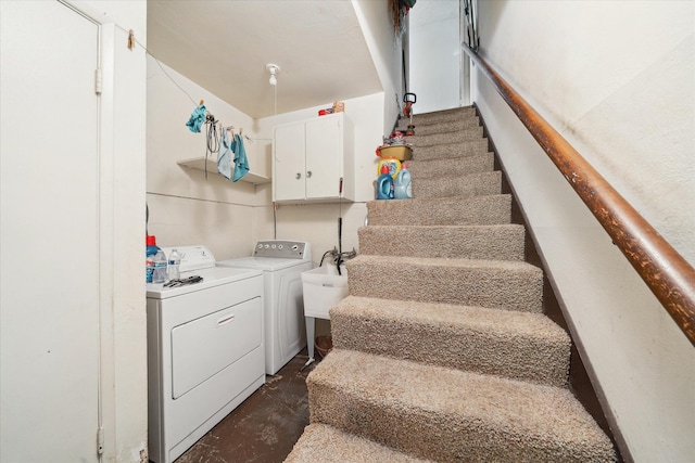 stairs featuring separate washer and dryer and concrete floors