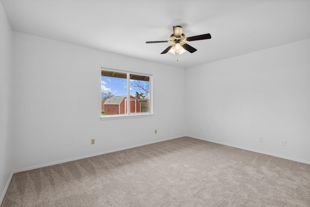 empty room featuring a ceiling fan, carpet flooring, and baseboards