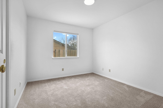 carpeted empty room with baseboards