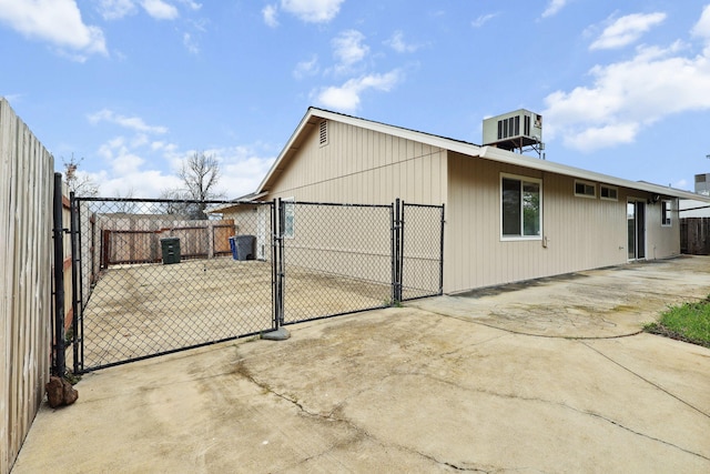 view of home's exterior with cooling unit, a gate, and fence