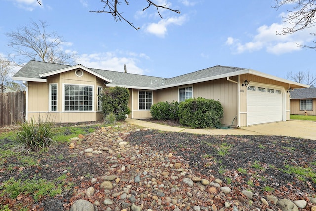 ranch-style home featuring a garage, fence, concrete driveway, and roof with shingles