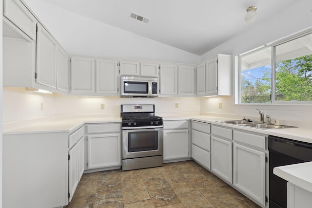 kitchen with visible vents, white cabinets, vaulted ceiling, stainless steel appliances, and a sink