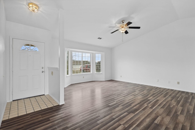 foyer featuring ceiling fan, lofted ceiling, wood finished floors, visible vents, and baseboards