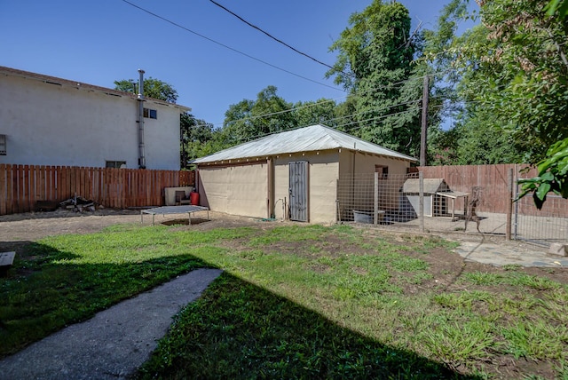 view of yard featuring an outbuilding and a trampoline