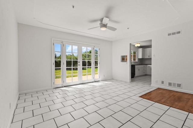 unfurnished living room with baseboards, a ceiling fan, visible vents, and light tile patterned floors