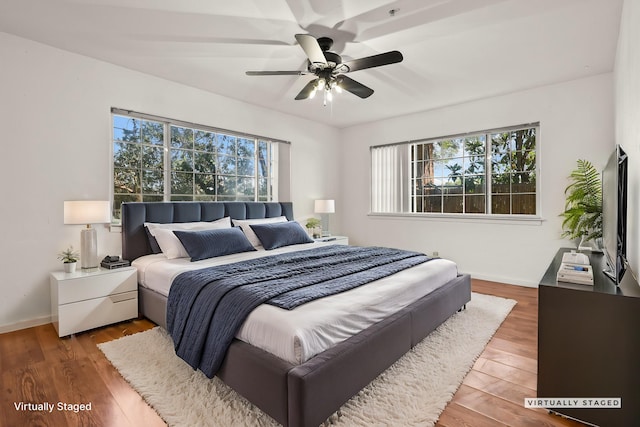 bedroom with baseboards, a ceiling fan, and wood finished floors