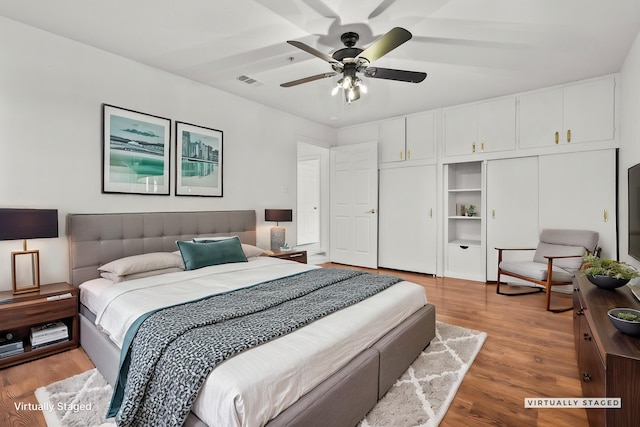 bedroom with ceiling fan, visible vents, and light wood-type flooring
