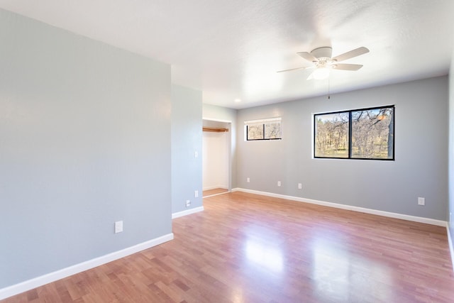 unfurnished room with ceiling fan and light wood-type flooring