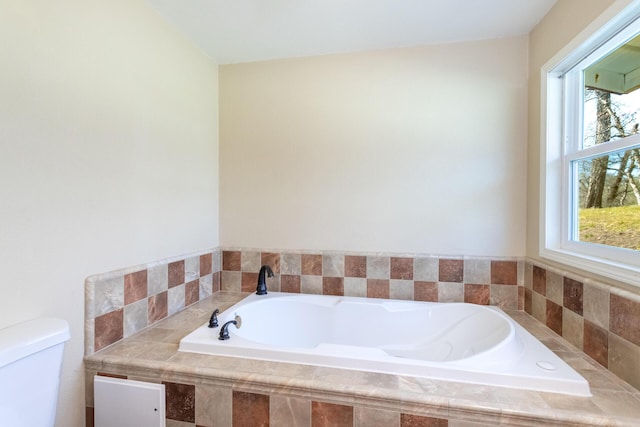 bathroom with a relaxing tiled tub and toilet