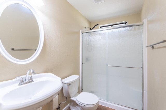 bathroom with sink, an enclosed shower, and toilet