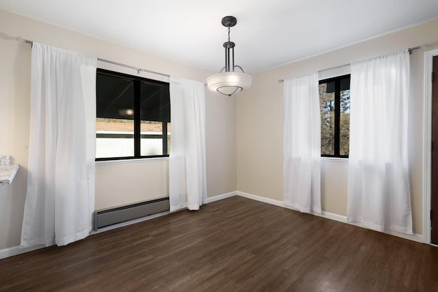 empty room featuring dark wood-type flooring, a baseboard radiator, and a healthy amount of sunlight