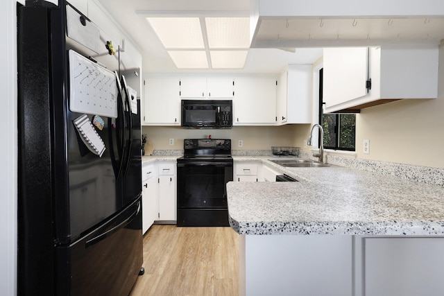 kitchen featuring white cabinetry, kitchen peninsula, and black appliances