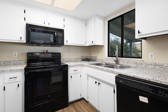 kitchen featuring white cabinets, light hardwood / wood-style floors, sink, and black appliances