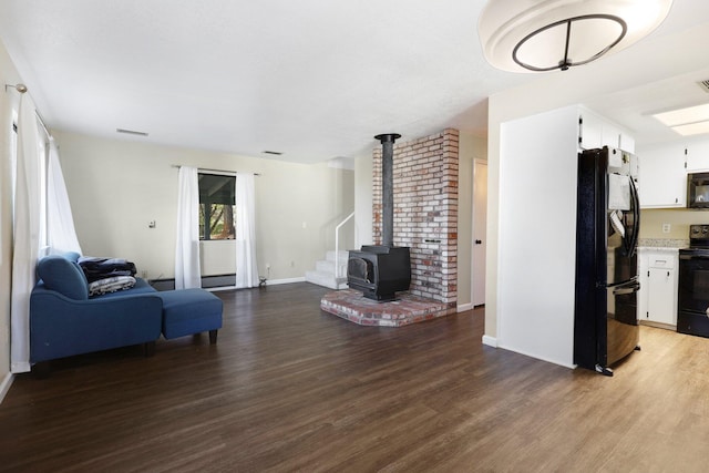 living room with wood-type flooring and a wood stove