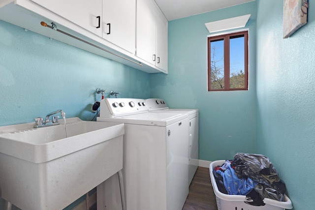 clothes washing area with cabinets, washer and dryer, sink, and dark hardwood / wood-style floors