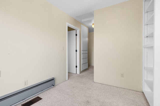 carpeted empty room with a baseboard radiator