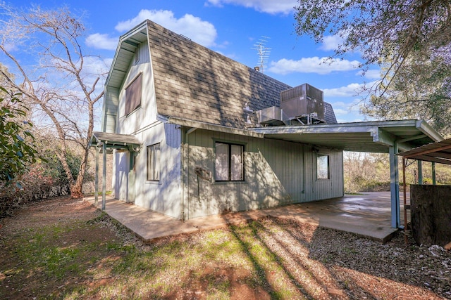 back of property featuring a carport and a balcony