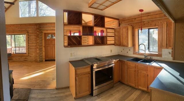 kitchen featuring sink, stainless steel range with electric stovetop, hanging light fixtures, light hardwood / wood-style flooring, and log walls