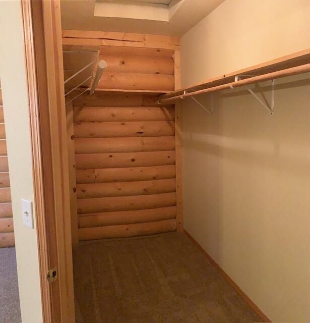 spacious closet featuring dark carpet