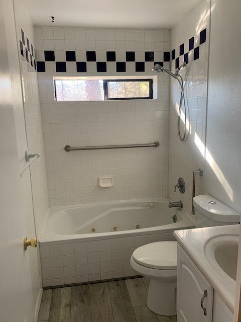 full bathroom featuring plenty of natural light, toilet, tiled shower / bath combo, and vanity