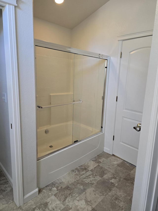 bathroom featuring combined bath / shower with glass door