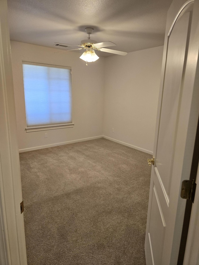 empty room featuring carpet floors, a textured ceiling, and ceiling fan