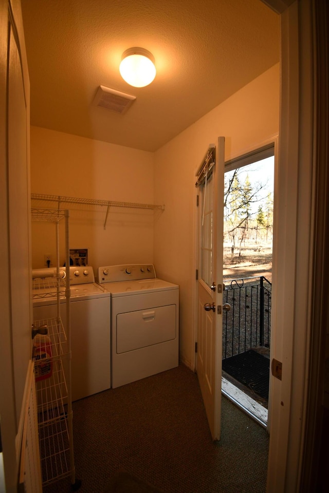 clothes washing area with dark carpet and washer and clothes dryer