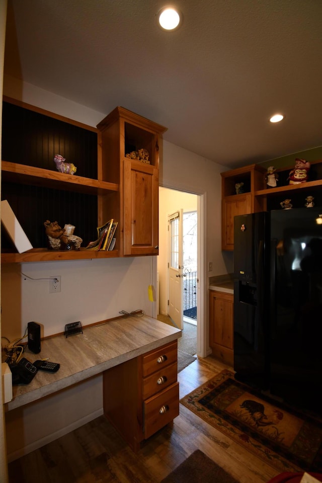 kitchen with black fridge and dark hardwood / wood-style floors